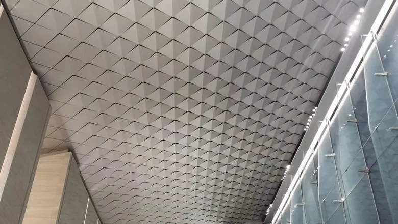 Large atrium ceiling in faceted aluminum panels with a linear lighting slot