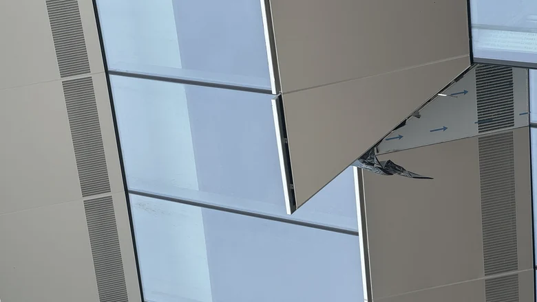 Perforated aluminum screen panels banding a glazed facade beside solid cladding